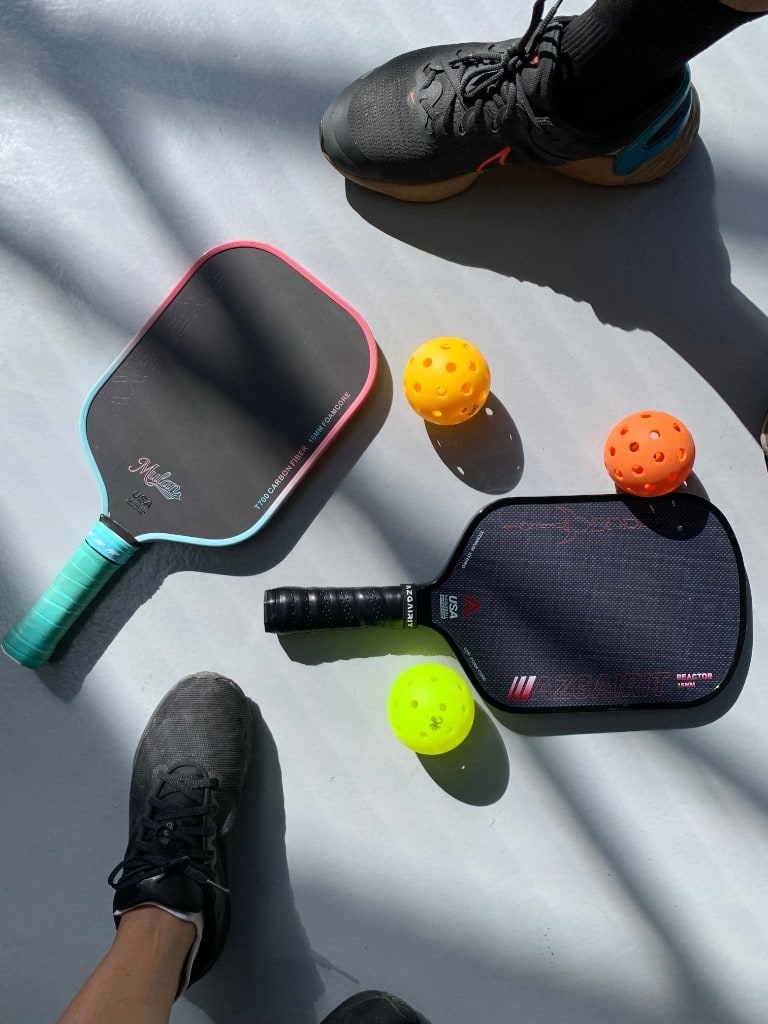 Pickleball paddles, balls and players’ shoes ready on court